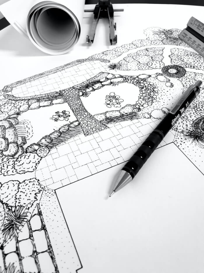 garden design drawing in progress with pen on top of drawing